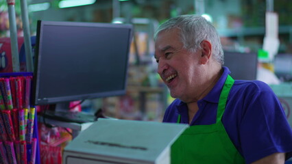 Female customer arriving at cashier checkout with smiling senior employee in supermarket scene