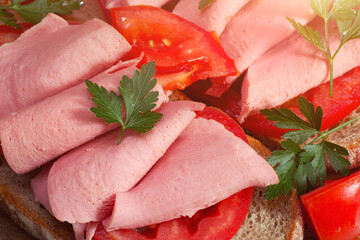 Sliced mortadella with tomatoes and parsley leaf. Homemade cold sandwiches for lunch. Closeup view. - 630084096