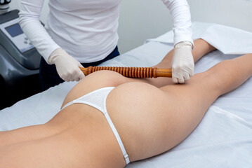 Body treatment in an aesthetic center with the technique of wood therapy for beauty, health and body care - obrazy, fototapety, plakaty