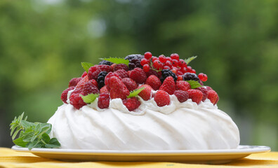 Pavlova cake - a meringue-based dessert with strawberries, blackberries, raspberries and mint leaves	