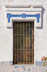 Ventana de tipo colonial español en edificio de principios del siglo XX, adornada con azulejos de la época.