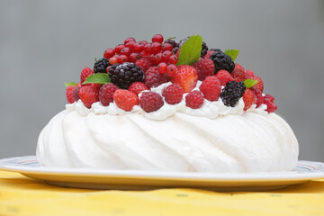 Pavlova cake - a meringue-based dessert with strawberries, blackberries, raspberries and mint leaves	