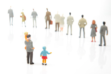 miniature people. little girl with other people stands against the background of other people on a...