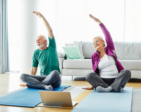  senior stretching exercise woman training lifestyle sport fitness home healthy man couple together pilates gym exercising fit laptop yoga meditation online class instruction