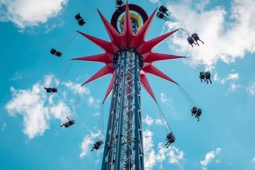 Fotobehang A spinning extreme attraction against the blue sky in the amusement park of the city of St. Petersburg. © Uladzimir