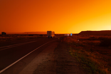 Fototapeta premium Freight delivery truck transporting cargo on interstate freeway at stunning sunset 