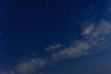 Fototapeta na wymiar Background of the night sky with many stars and clouds
