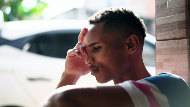 One preoccupied young black Brazilian man struggling with regret and bad memories, close-up face of an African American person with pensive worries