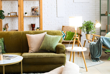 Interior of living room with glowing lamp and green sofa