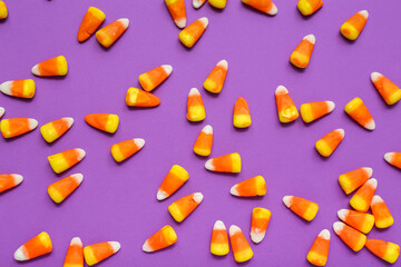 Tasty Halloween candy corns on purple background