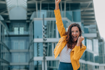 middle-aged woman in the street with euphoric expression of success and joy