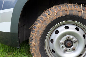 Motorhome wheel caked in mud, after spinning on a wet field.