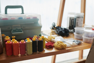 Thread reels and yarn on desk of craftsperson