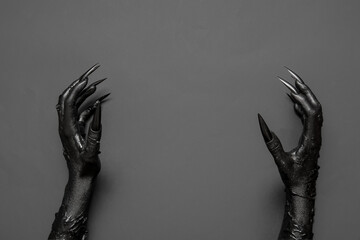Black hands of witch on grey background. Halloween celebration