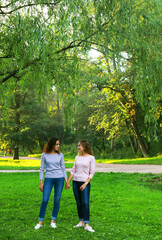 Fototapeta premium Mother and adult daughter hold hands in the park.