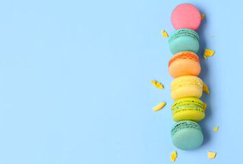 Different tasty sweet macaroons on blue background