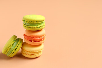 Different tasty sweet macaroons on orange background