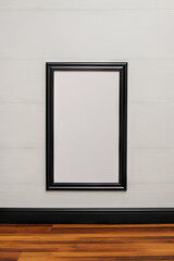 A black picture frame hanging on a white wall. =