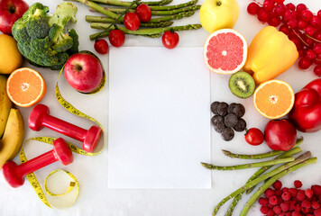 Paper with copy space, fruits, berries, vegetables and dumbbells, measuring tape
