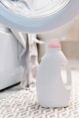 Washing gel liquid laundry detergent and fabric softener nearby washing machine, peshtemal towel in washing machine. High quality photo