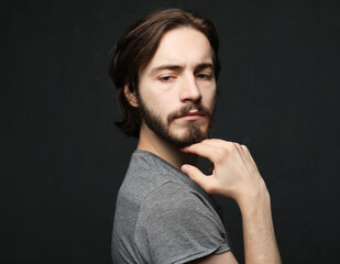 Handsome young male model, with beard and mustache, stylishly dressed.