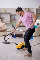 Young male contractor cleaning the house