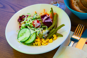 Deliciously salad of corn, cucumbers, cabbage and boiled bean with carrot