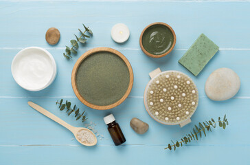 Composition with cosmetic clay and spa products on wooden background, top view