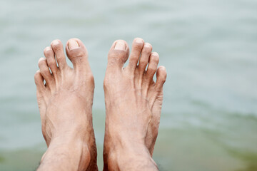 A pair of male feet on the beach