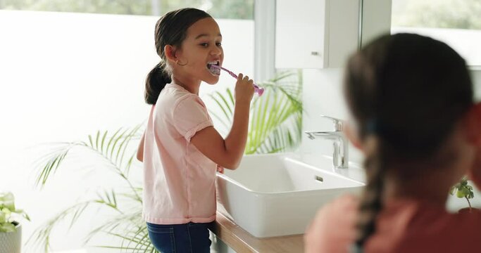 Siblings, morning or children in bathroom brushing teeth in daily grooming routine together at home. Healthy kids, oral care or girls cleaning mouth with toothbrush or toothpaste for dental health