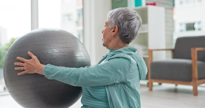 Senior woman, exercise and ball in home for fitness, wellness and workout in retirement. Old lady, movement and mobility with equipment on floor in living room for care of healthy muscle development