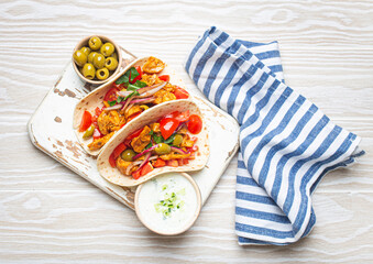 Traditional Greek Dish Gyros: Pita bread Wraps with vegetables, meat, herbs, olives on rustic...