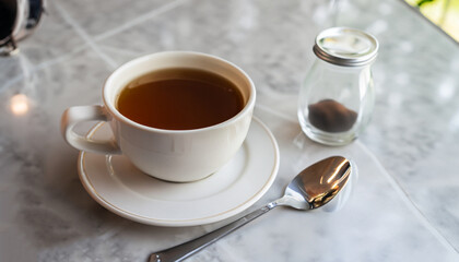 Hot coffee and hot tea place on the marble table in early morning with copyspace, white cup and silver spoon.
