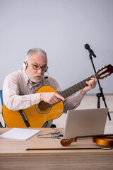 Old male music teacher in the classroom