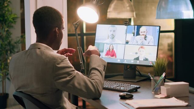 Employee teleworking from home in online videocall with coworkers, discussing company project tasks during nightshift. Businessman in teleconference meeting over the internet with colleagues