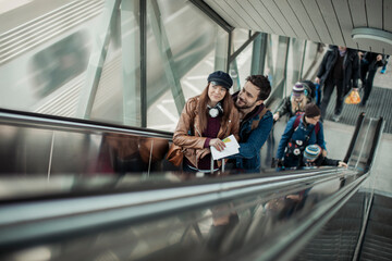 Young couple on an escalator in a train station going on a vacation traveling