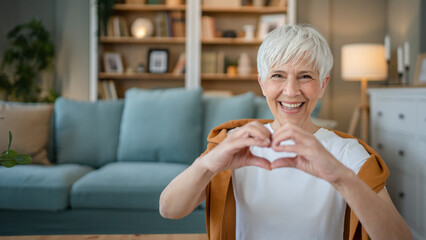 healthy senior caucasian woman showing hart hand gesture health love