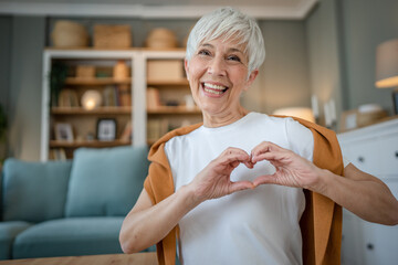 healthy senior caucasian woman showing hart hand gesture health love