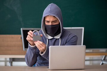 Young male hacker sitting in the classroom
