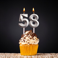 Birthday candle number 58 - Anniversary cupcake on black background