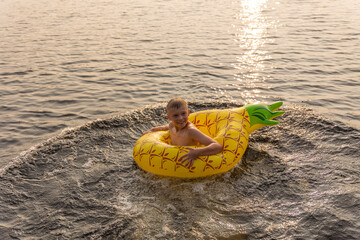 Lake Adventures: boy and Pineapple Floaty on the Deck in Canada during sunset