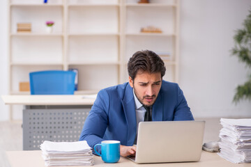 Young male employee and too much work in the office