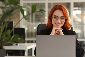 Happy woman working with laptop in office