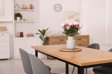 Stylish dining room with cosy furniture and flowers