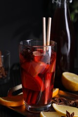 Glass of aromatic punch drink and ingredients on table