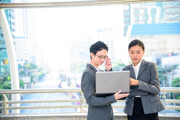 Business people meeting outside office using laptop team discuss together. Team partners drink coffee in modern city. Hands holding take away coffee cup talking together. Partner Business people talk