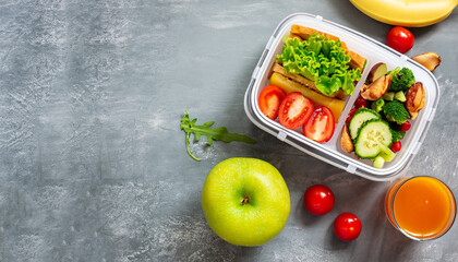 Healthy lunch to go. Fruits and vegetables packed in lunch box. Healthy eating concept. View from...