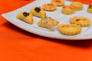 snacks on a plate, snacks in white porcelain plate and orange background, party snacks, snacks on orange background, food background