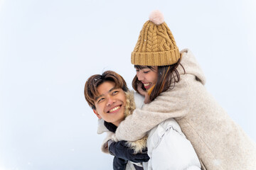 Happy Asian couple have fun playing snow ball during travel small town and forest mountain together...