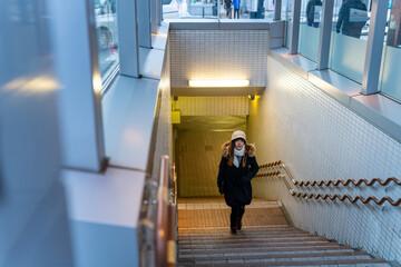 Young Asian woman walking up on staircase at subway station in the city at night. Attractive girl enjoy urban outdoor lifestyle travel city street by public transportation in Japan on winter vacation. © CandyRetriever 